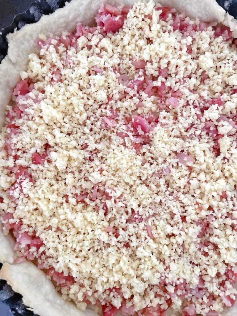 Quiche Lorraine dough with chopped ham and grated cheese.