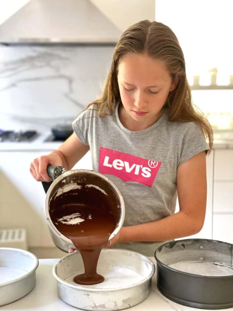 Pouring Thermomix chocolate cake batter into cake tins