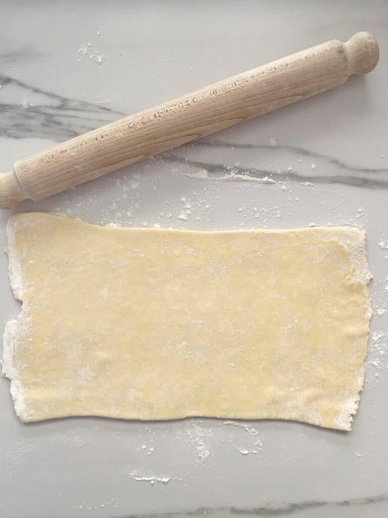 rolled out Sausage Rolls dough with rolling pin 
