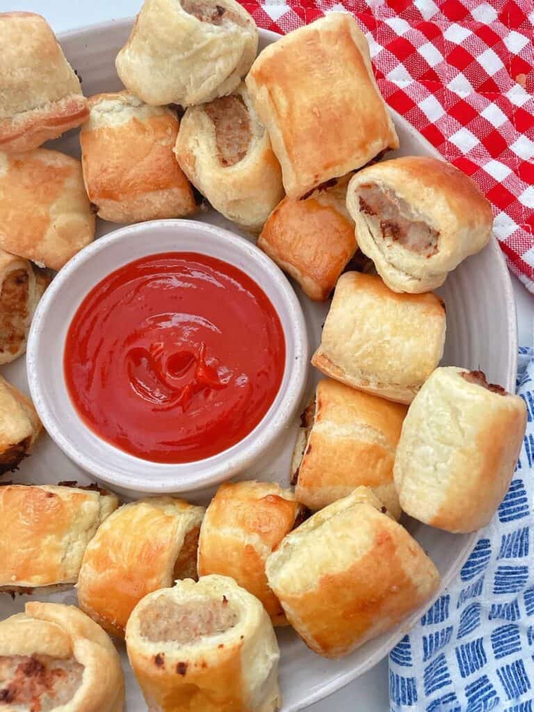 Party plate of Thermomix Sausage Rolls with tomato sauce