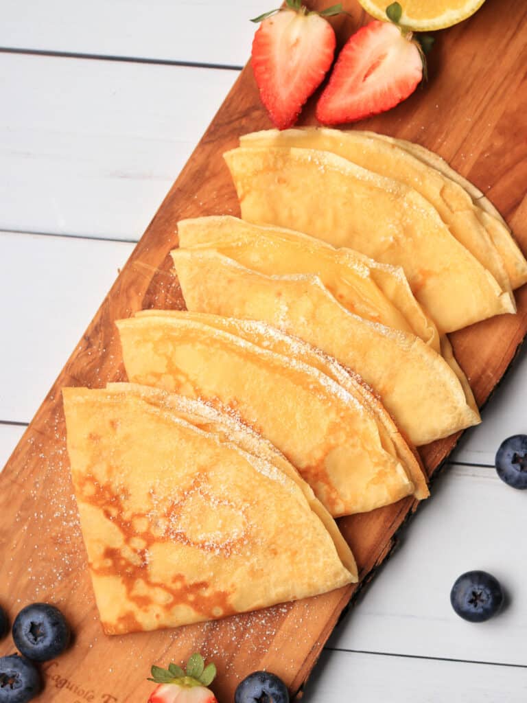Thermomix Crepes folded on a board with berries
