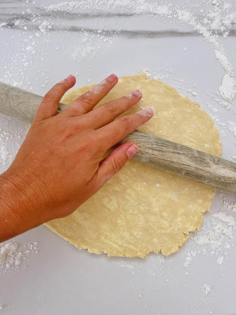 Rolling apple pie crust with rolling pin
