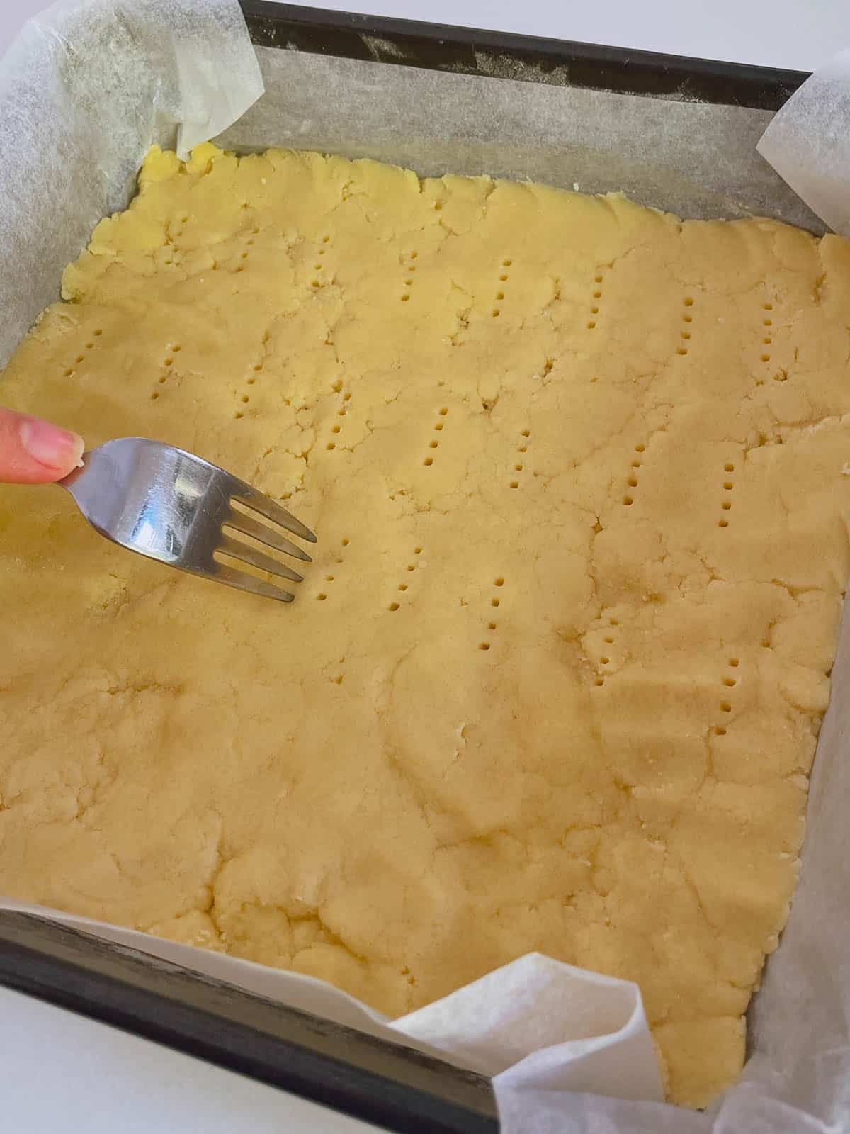 Pricking shortbread with a fork.