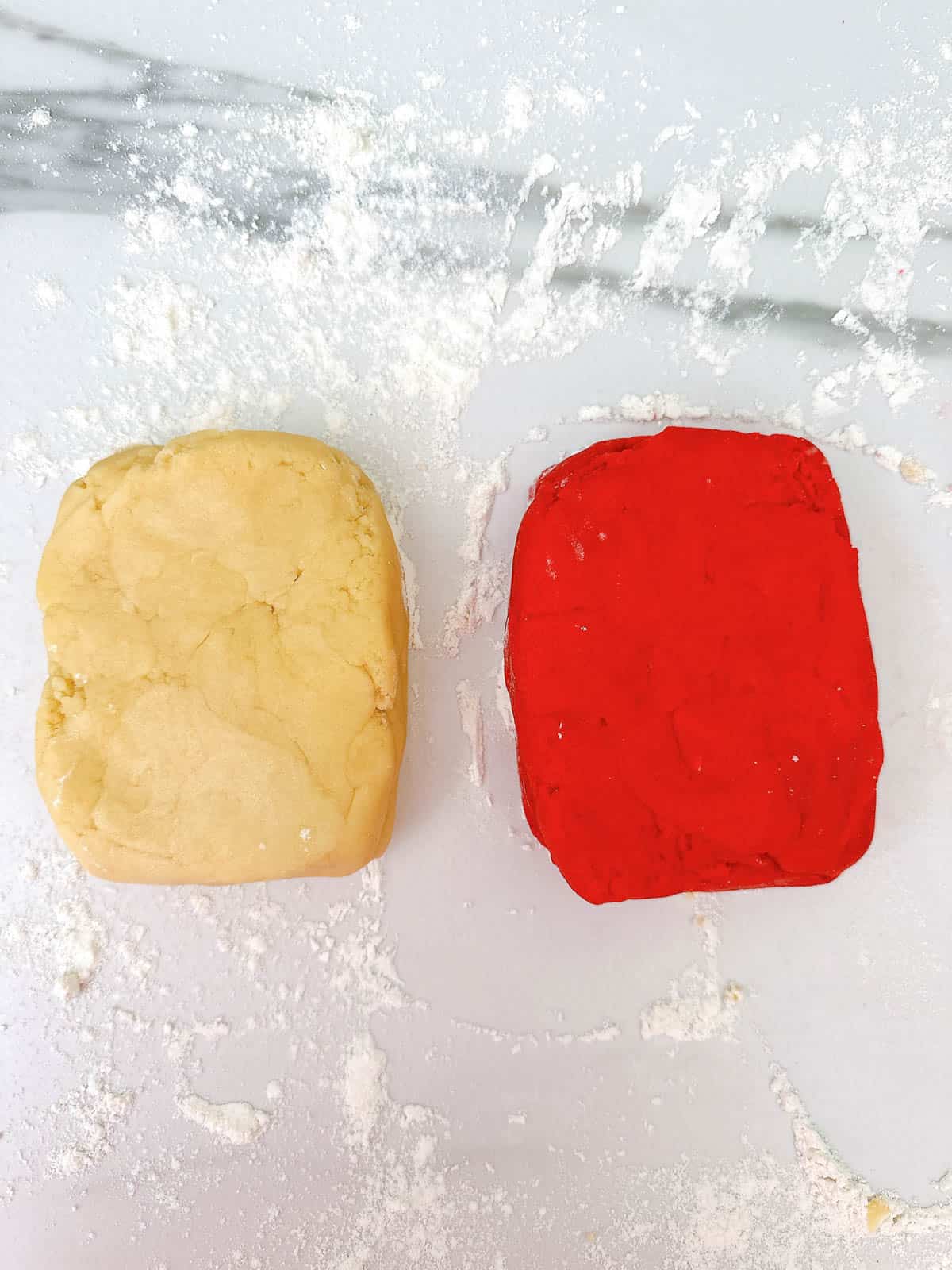 Two squares of cookie dough - one plain, one red. 
