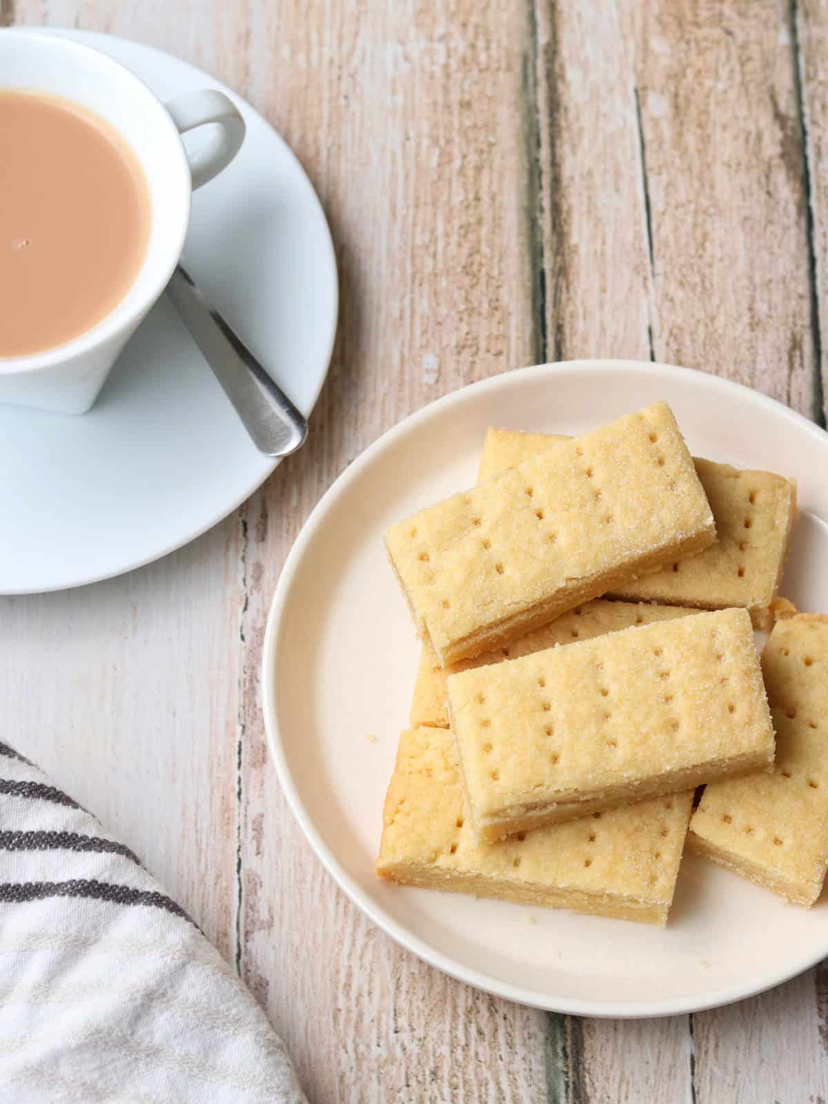 Homemade Thermomix shortbread on a plate on a table with a cup of tea. 