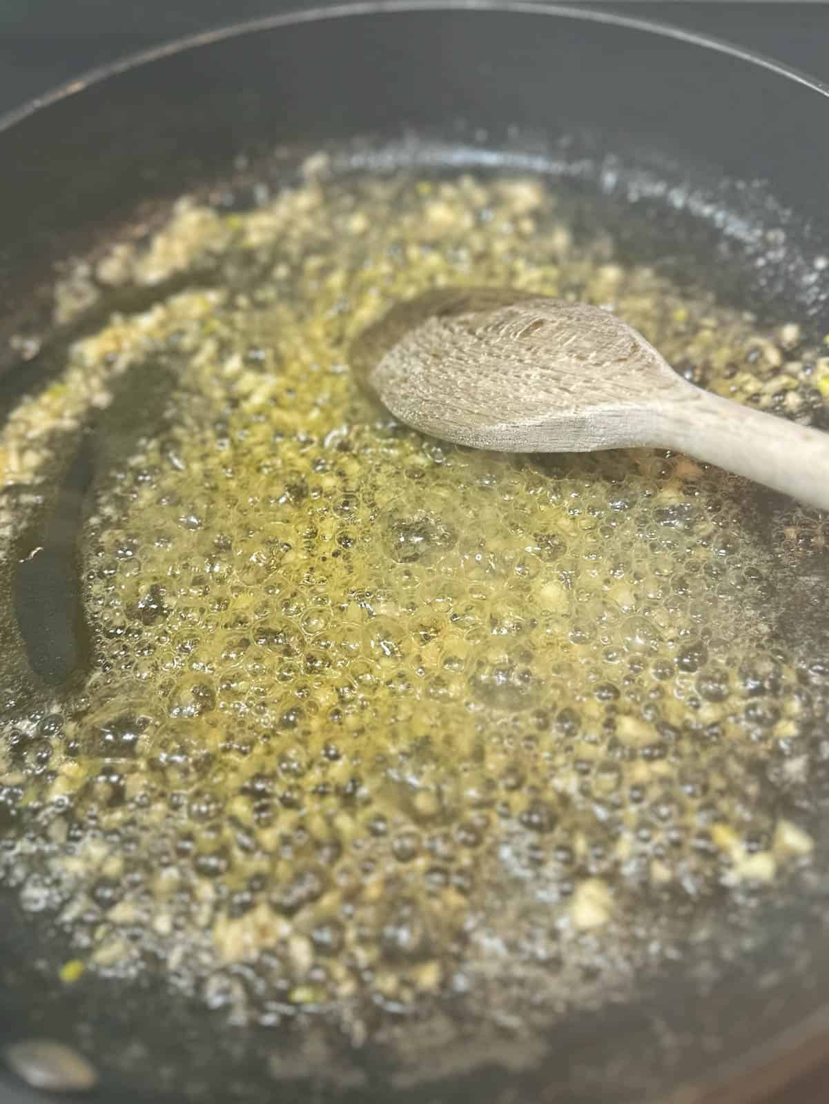 Cooking garlic in butter in a frying pan. 