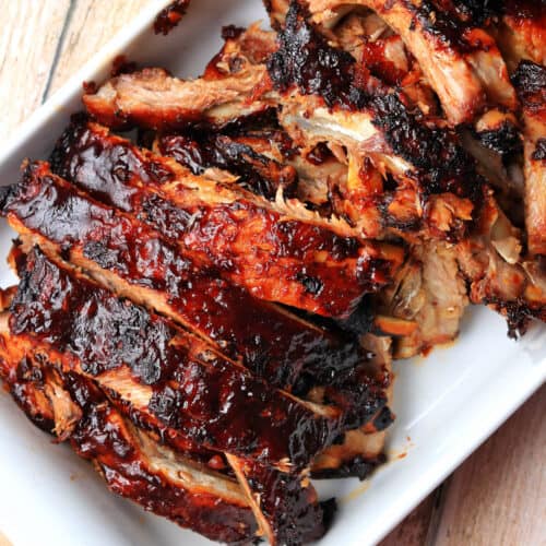 Oven baked barbecue ribs in a dish.