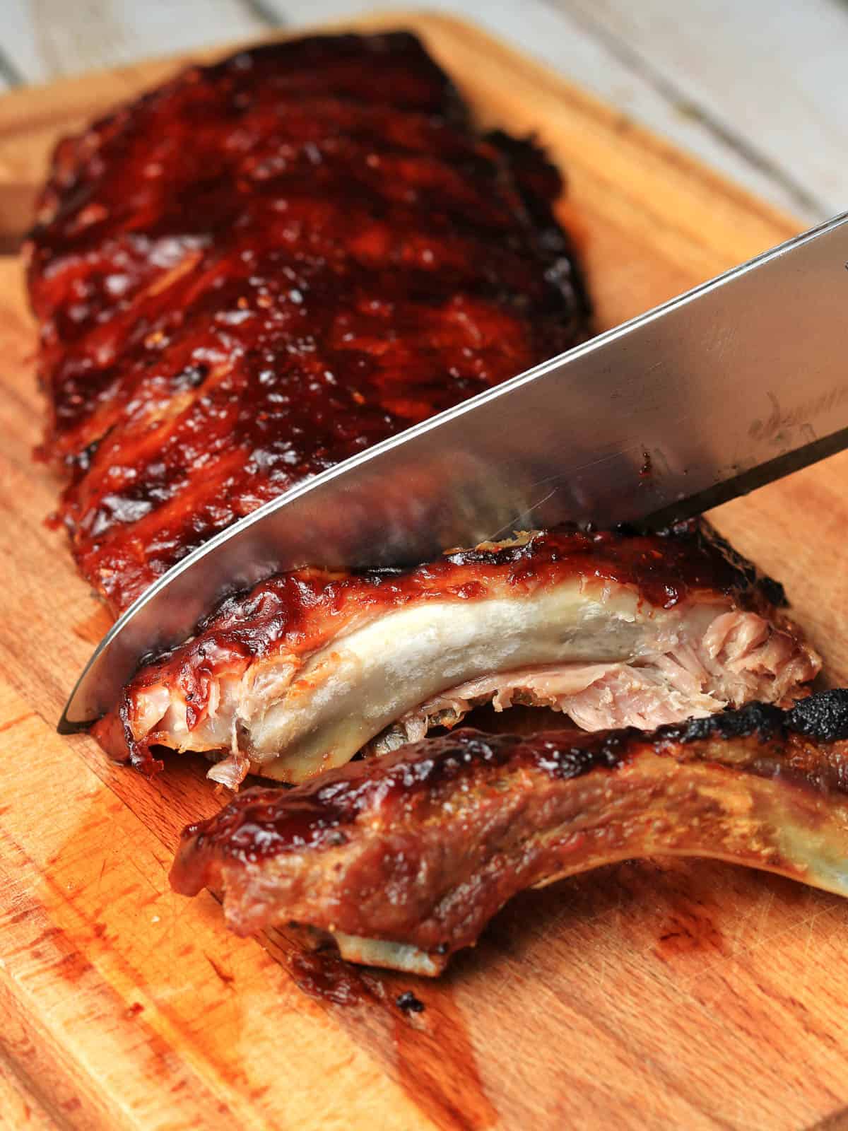 Cutting barbecue ribs with a sharp knife. 