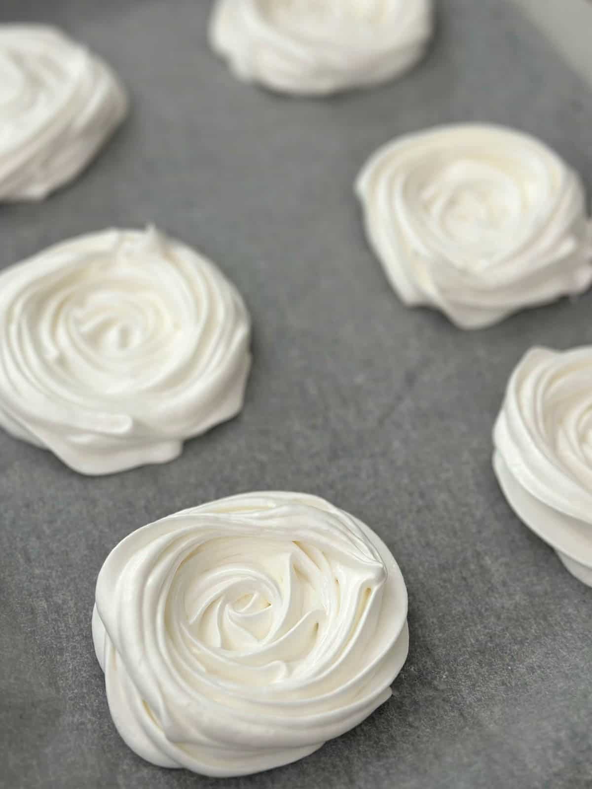 Piped meringues on a baking tray. 