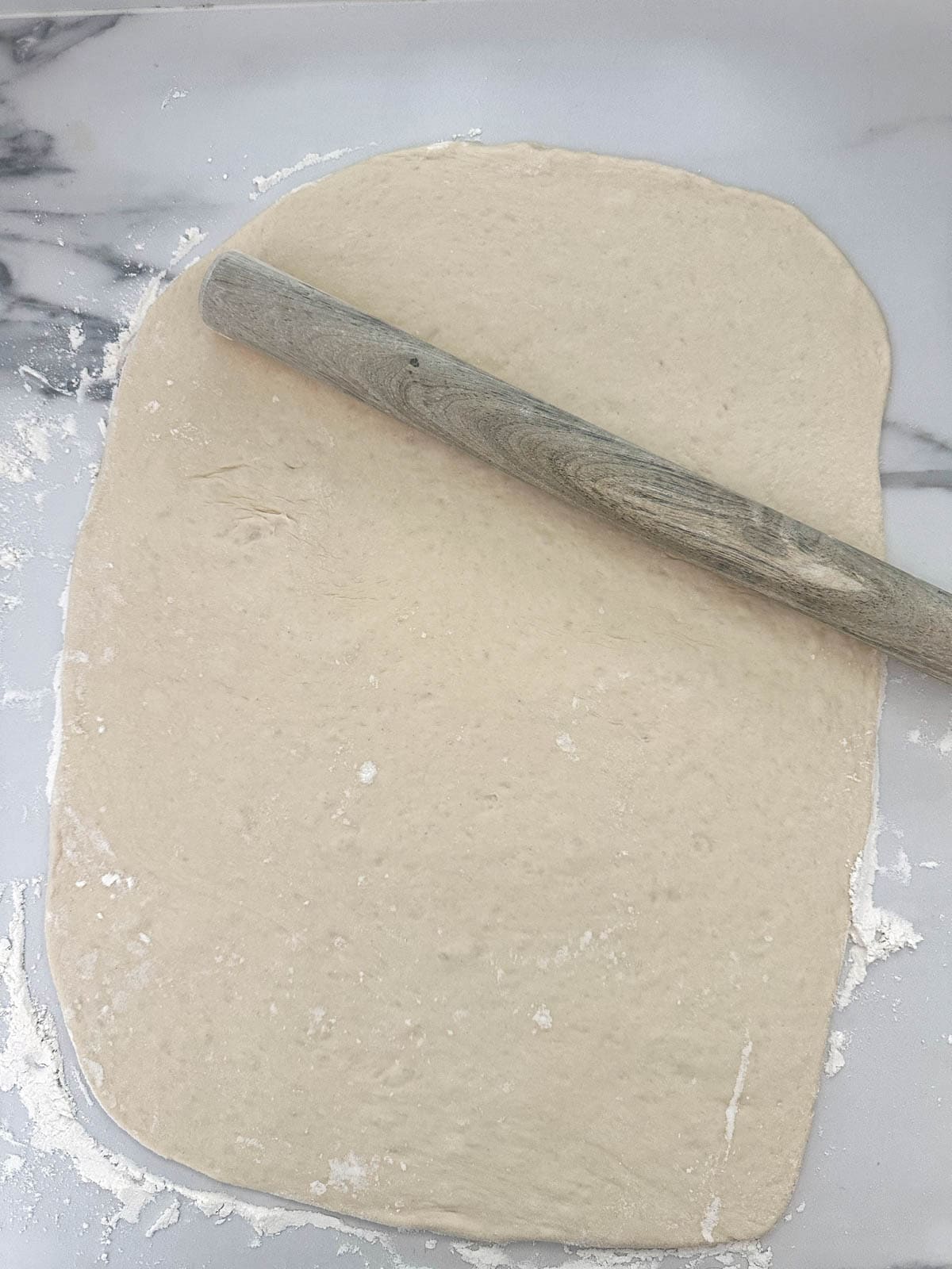 Thermomix dough on rolled into a large rectangle with a rolling pin. 