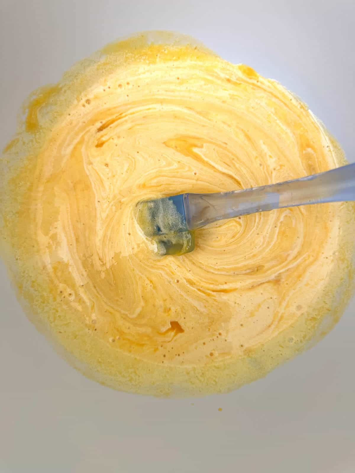 Mango and egg yolk mixture mixed together.