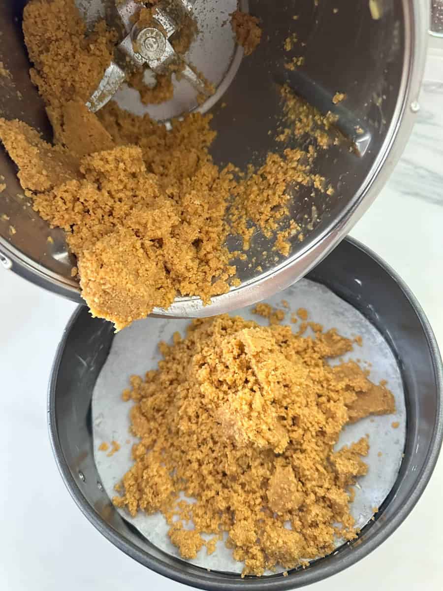 Tipping Thermomix Cheesecake base into cake tin. 