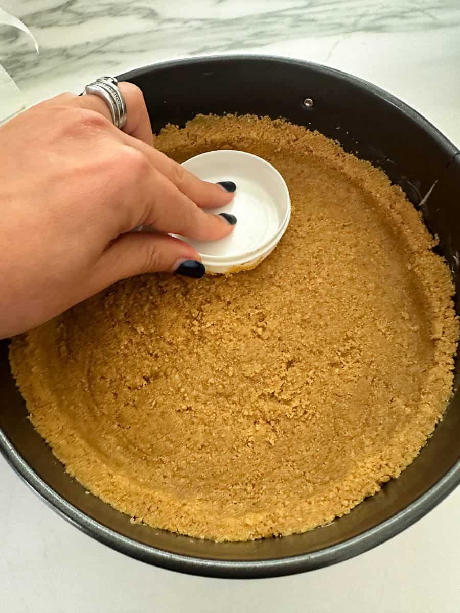 Pressing Thermomix Cheesecake base into cake tin.