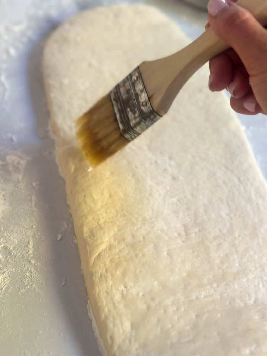 Brushing the dough with olive oil.