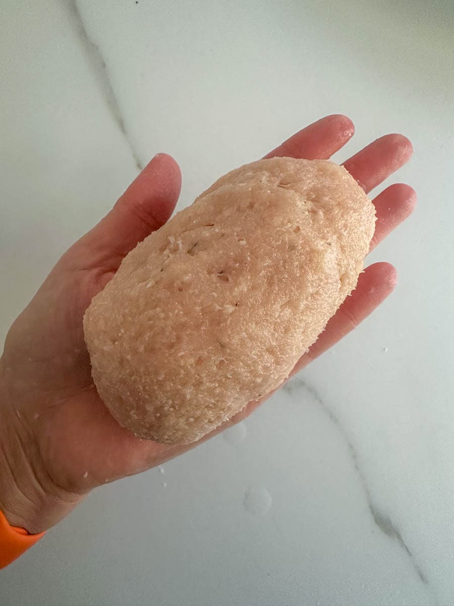 Closeup of hands making Chicken Kiev. 