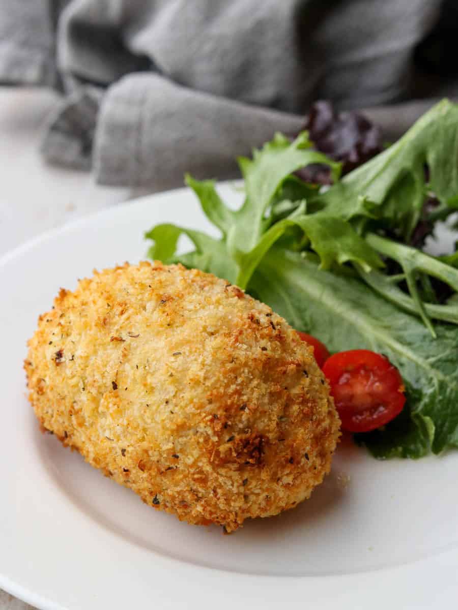 Thermomix Chicken Kiev on a plate with salad. 