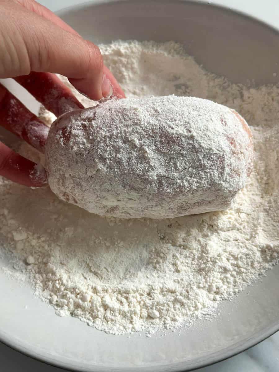 Rolling Chicken Kiev in flour. 
