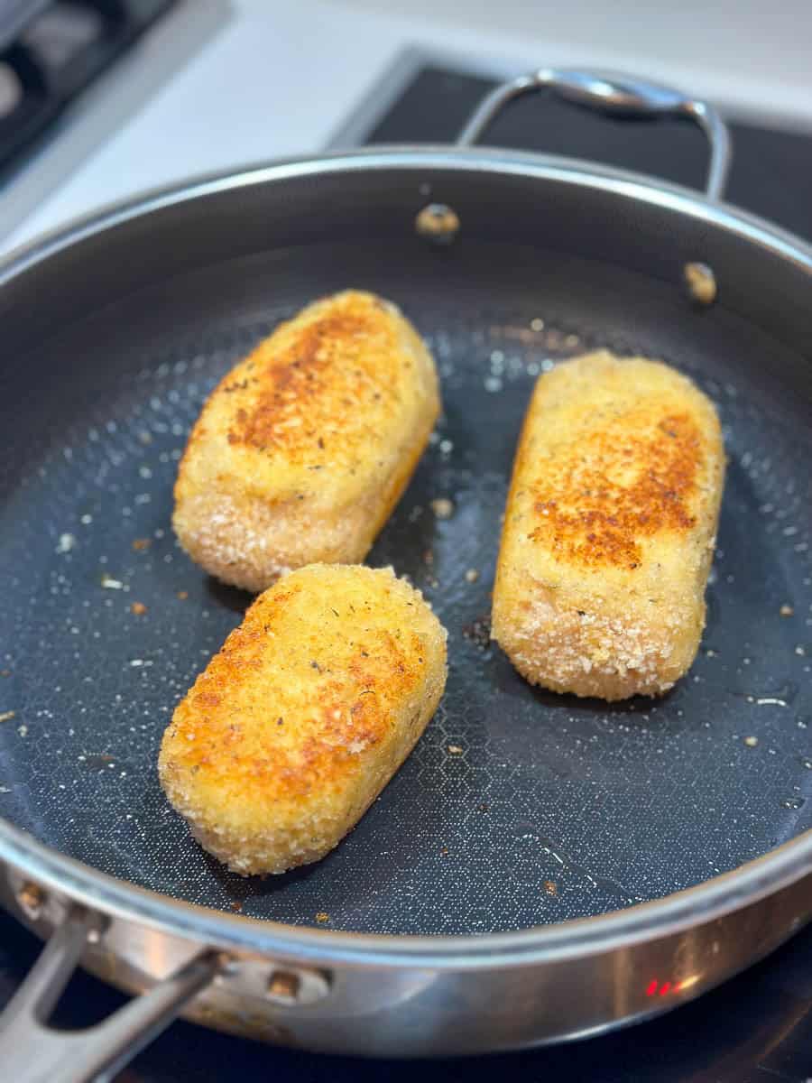 Frying Chicken Kievs in a frying pan.