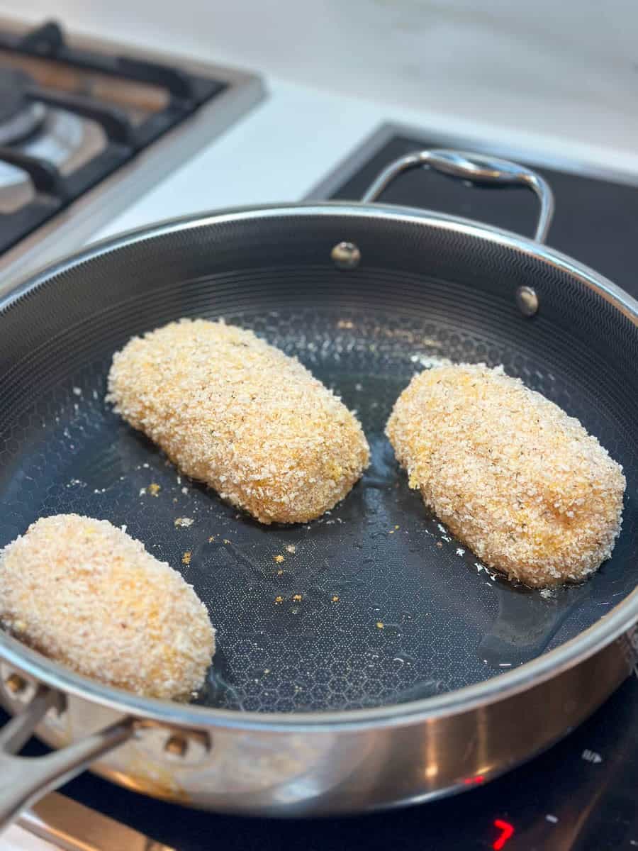 Frying Chicken Kievs in a frying pan.