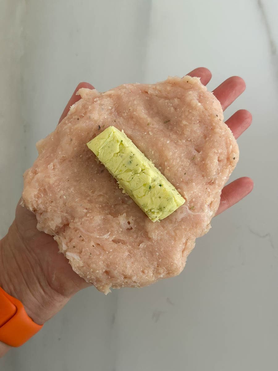 Closeup of hands making Chicken Kiev. 
