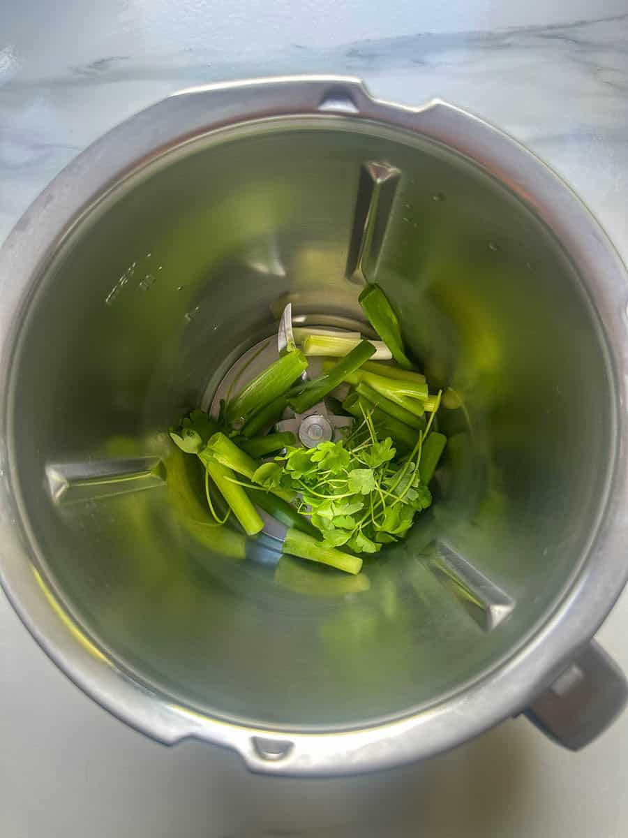 Spring onions and parsley in a Thermomix bowl.