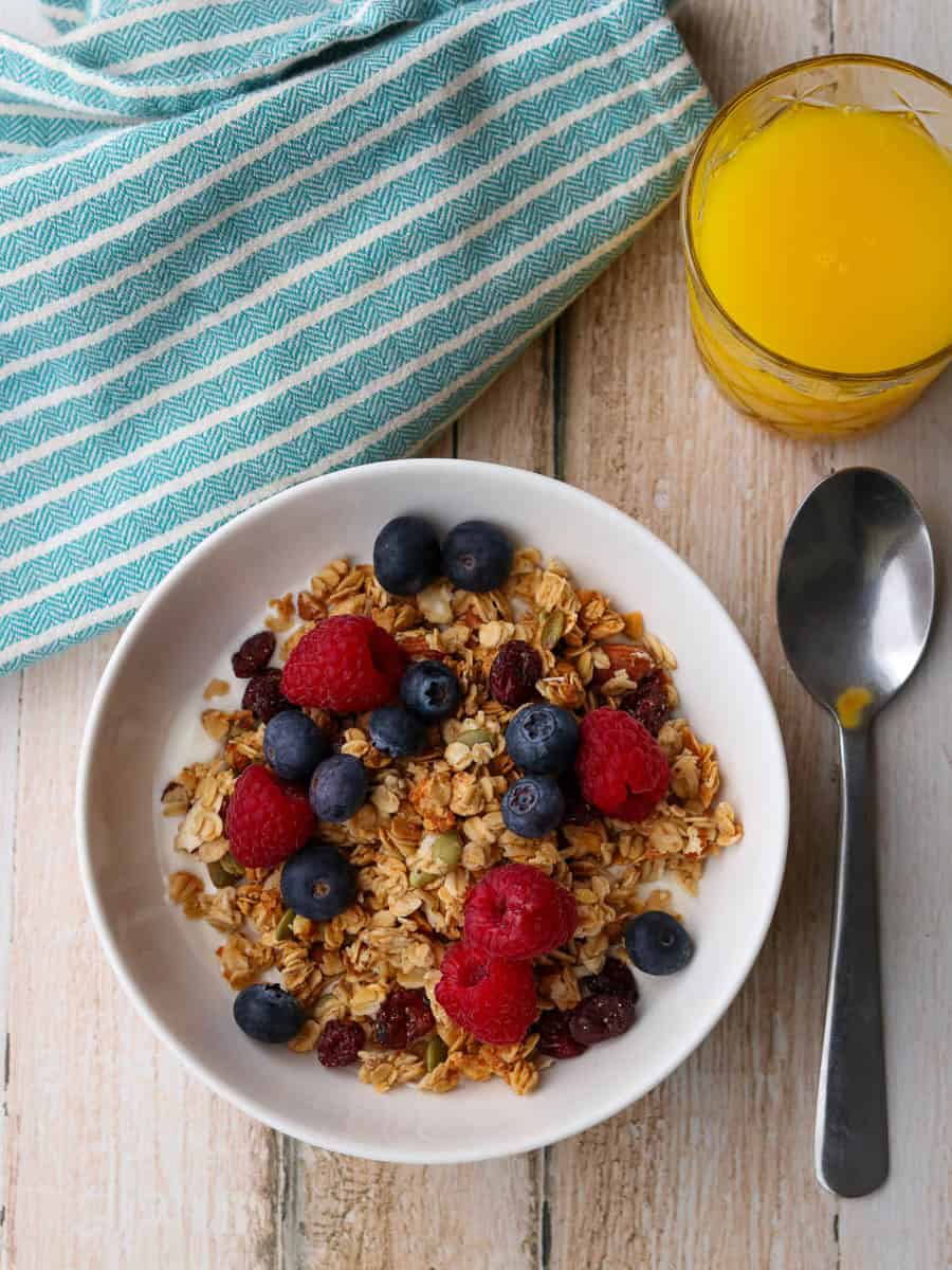 Thermomix granola in a bowl with yoghurt and berries.