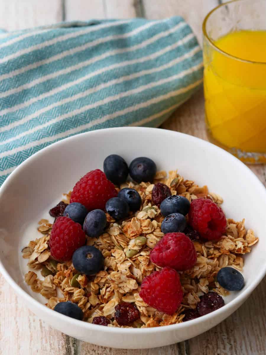 Thermomix granola in a bowl with yoghurt and berries.