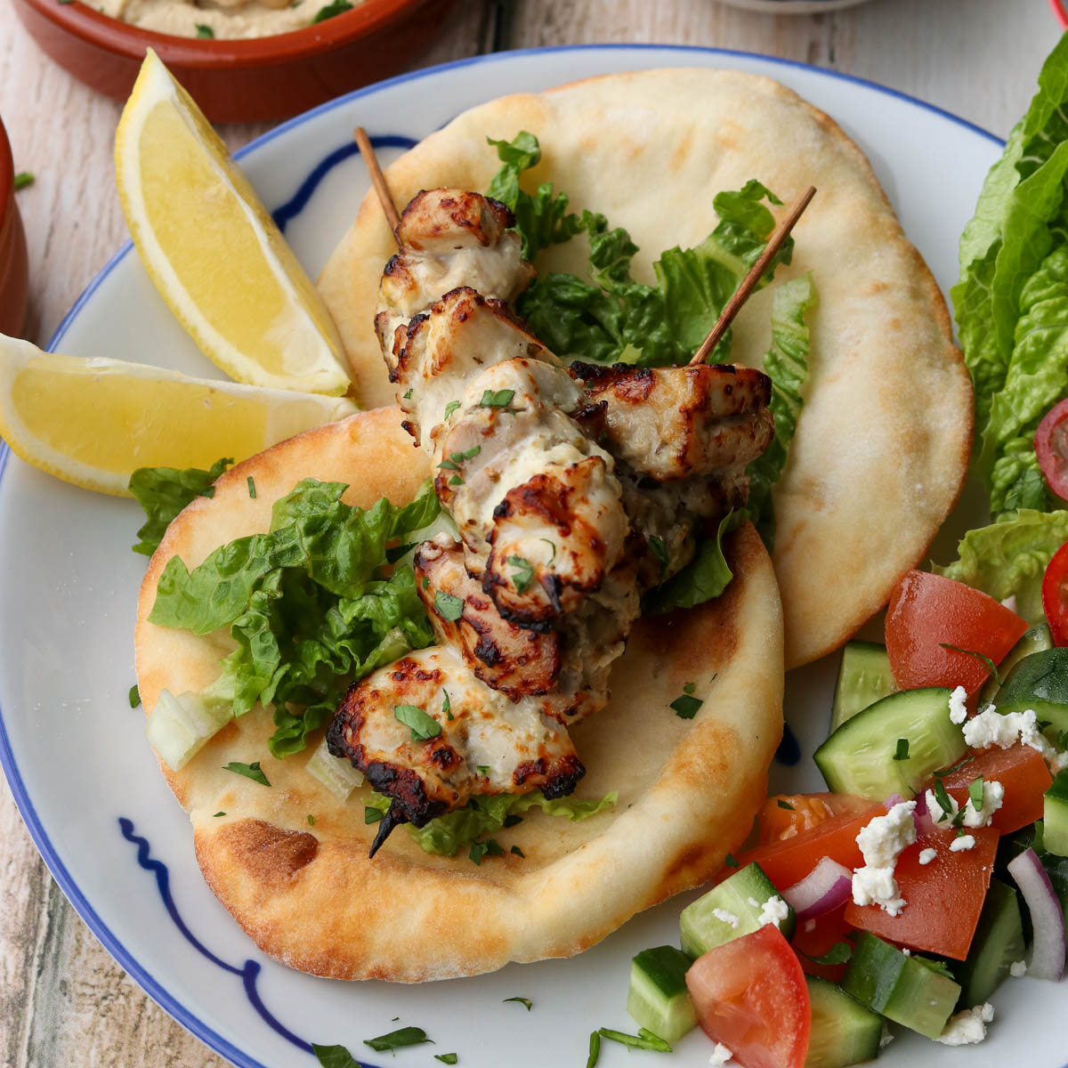 Air fryer chicken souvlaki served with flatbread and salad.