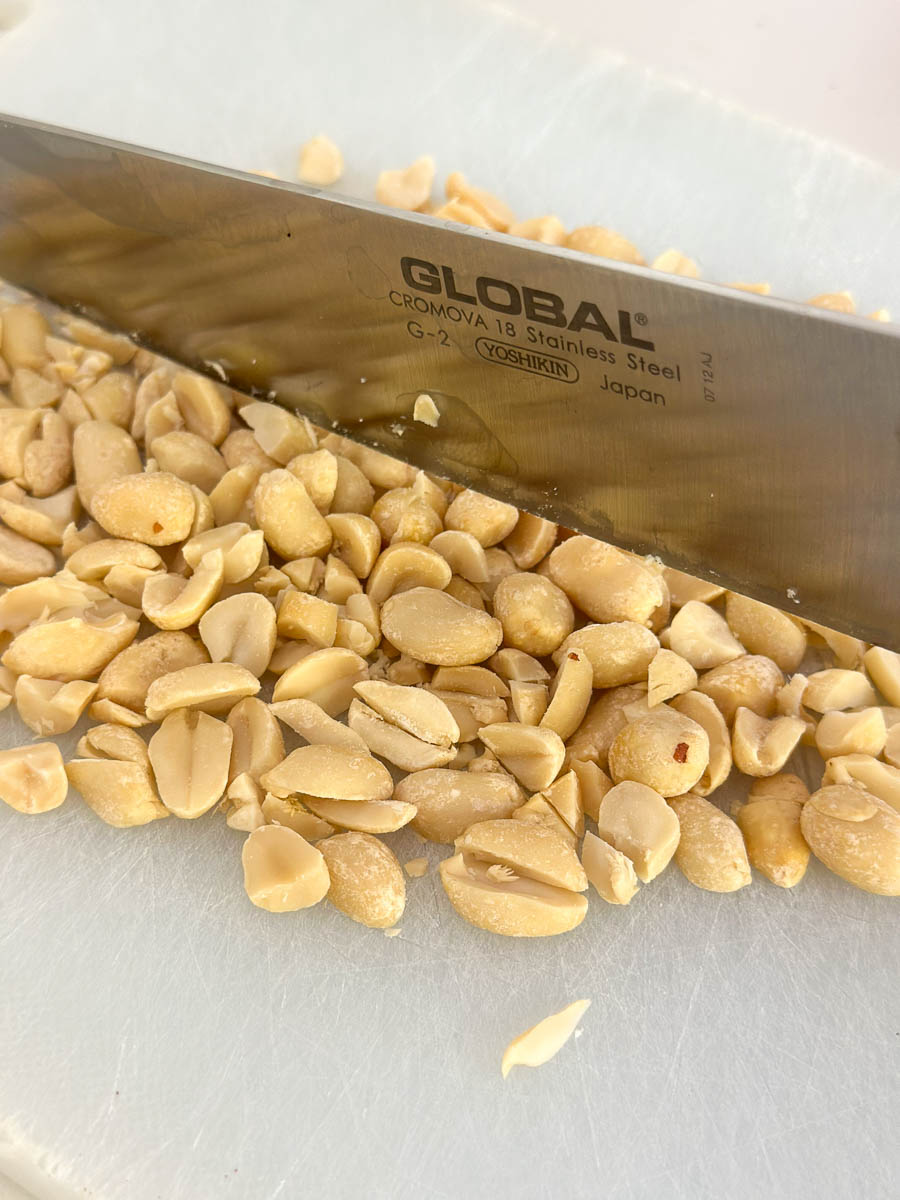 Chopping peanuts with a knife.
