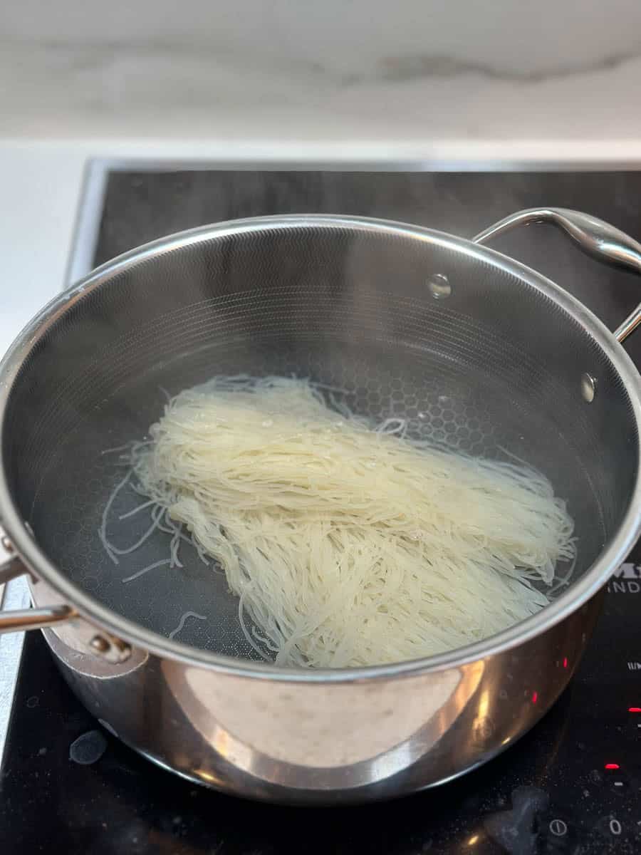 Cooking rice noodles in a saucepan.