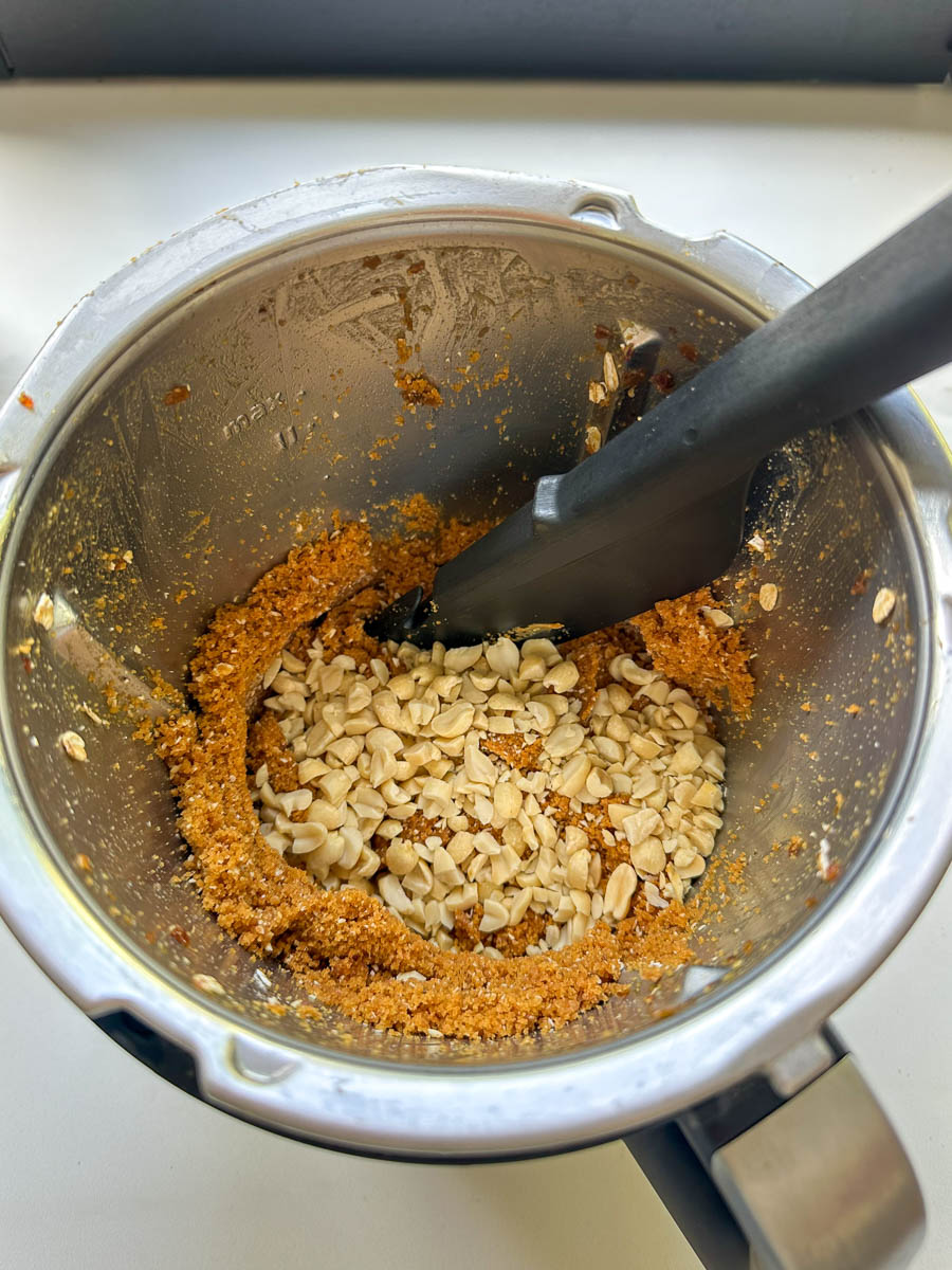 Adding peanuts to Thermomix Peanut Butter Chocolate Energy Bites mixture.